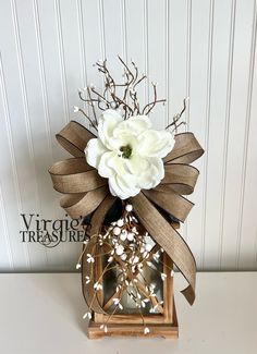 a white flower sitting on top of a wooden lantern