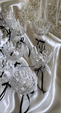 several crystal bowls with black ribbons on a white cloth