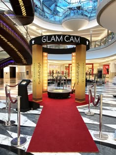 the entrance to glam cam is lit up with lights and red carpeted stairs