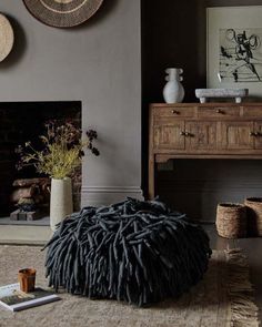 a living room filled with furniture and a fire place in front of a painting on the wall