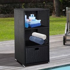 an outdoor storage unit next to a swimming pool with towels and other items on it