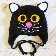 a crocheted black cat hat with yellow eyes