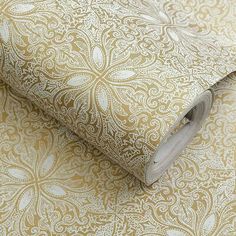 a close up view of a wallpaper with gold and white designs on it's surface