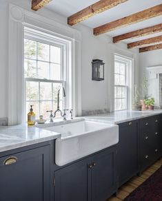 a kitchen with white counter tops and blue cabinets