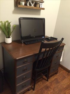 a laptop computer sitting on top of a wooden desk next to a chair and potted plant