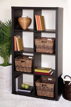 a book shelf with baskets and books on it