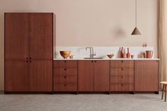 a modern kitchen with wooden cabinets and white counter tops is shown in this image from the side view