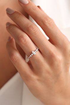 a woman's hand wearing a diamond ring