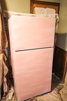 a pink refrigerator sitting on top of a bed