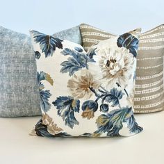 three pillows with blue and white flowers on them