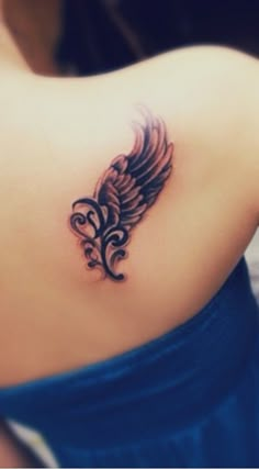 a woman's back with a tattoo on her left shoulder and an angel wing