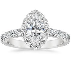 a white gold engagement ring with an oval cut diamond and pave set diamonds around the band