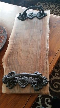 a piece of wood sitting on top of a wooden table next to a metal object