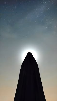 the silhouette of a person wearing a black cloak