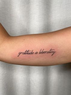 a person with a tattoo on their arm that says, gratitude is everything