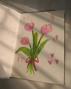 a drawing of pink flowers with green stems and hearts in the shadows on a sheet of paper