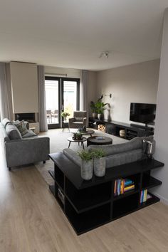 a living room filled with furniture and a flat screen tv on top of a hard wood floor