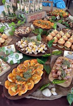 a table topped with lots of different types of food on plates and trays next to each other