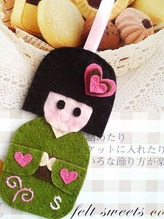 an ornament made to look like a girl with hearts on her head and green sweater