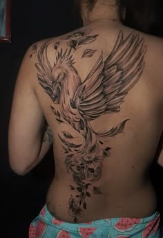 a woman with a bird tattoo on her back