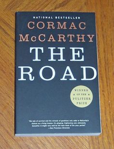 the road by cormac mccarity on a wooden table with a pen