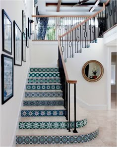 the stairs are decorated with blue and white tile designs, along with pictures on the wall