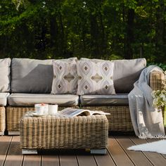 a wicker couch sitting on top of a wooden deck