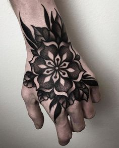 a black and white flower tattoo on the left hand