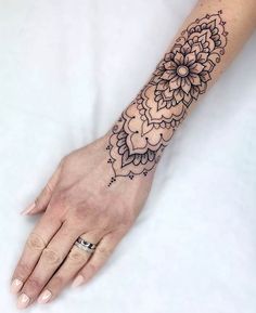 a woman's hand with a flower tattoo on it