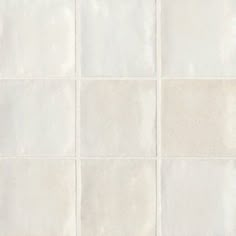 a white tiled wall with several squares in it