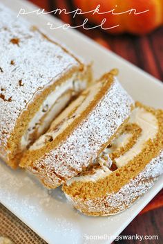 a white plate topped with cake covered in powdered sugar and sliced into four pieces