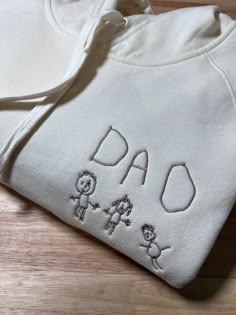 a white sweatshirt with the words dad embroidered on it