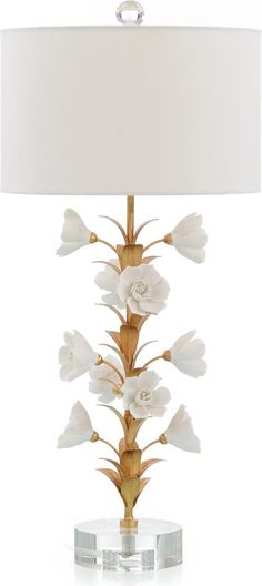 a table lamp with white flowers on it and a beige shade over the light fixture