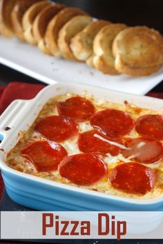 pepperoni pizza dip in a blue casserole dish on a red tablecloth