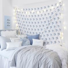 a bed with white sheets and blue pillows in a bedroom decorated for christmas or new year's eve