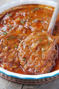 two pieces of meat covered in sauce and garnished with parsley