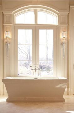 a white bath tub sitting next to a window