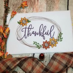 a card with the word grateful written on it and some flowers in front of it