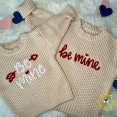 two sweaters with the words be mine and be mine written in red on them