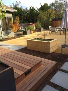 a wooden deck with raised planters in the middle