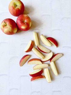 apples are cut in half and placed on a white surface next to each other,