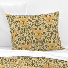 a bed with two pillows and a pillow case on it's side, both have yellow flowers