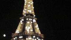 the eiffel tower lit up at night with lights on it's sides