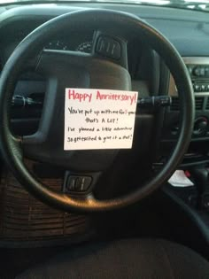 a happy anniversary note on the steering wheel of a car