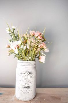 a white mason jar filled with pink and white flowers