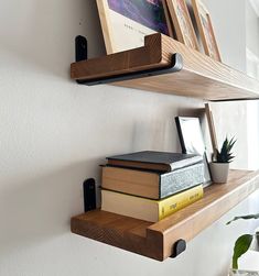 two wooden shelves with books and plants on them