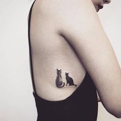 a woman with a cat tattoo on her left side ribcage, showing the silhouettes of two cats