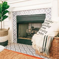 a living room filled with furniture and a fire place covered in pillows next to a potted plant