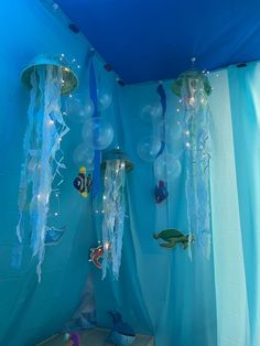 an ocean themed bedroom with jellyfish and sea creatures hanging from the ceiling, along with blue walls