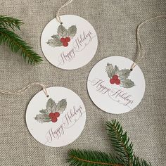 three christmas ornaments with holly leaves on them